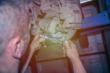 mechanic changes the tire on the car in the garage