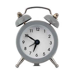 A gray clock with an alarm clock on a white background with arrows showing the time six hours fifty minutes or eighteen hours fifty minutes