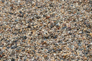 Stone texture background. Close-up of gravel or pepples stones at summer beach with selective focus. Natural design backdrop for your project. Macro.