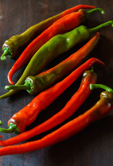 Red and green hot chili peppers on a dark background. Traditional spicy food.