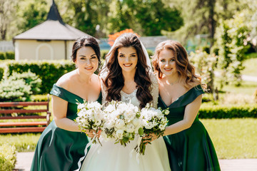 Sweet bride with her bridesmaids posing in the park.