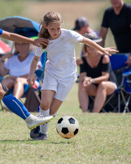 Obraz premium Young athletic teen girl playing in a soccer game