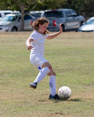 Young athletic teen girl playing in a soccer game © Joe