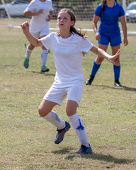 Fototapeta premium Young athletic teen girl playing in a soccer game
