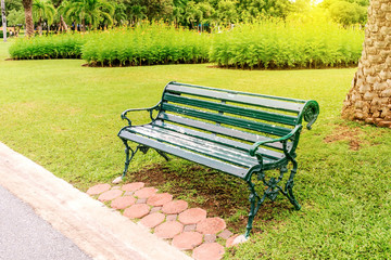 empty bench in the park, metal garden chair on green grass, Chairs on the lawn in the park, The chair in the park on grass, bench in green park with path way