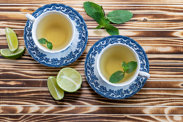 Fresh aromatic mint tea with lime on dark wooden background. Healthy vitamin autumn drink.