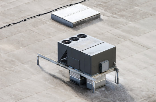 The external units of the commercial air conditioning and ventilation systems are installed on the roof of an industrial building.