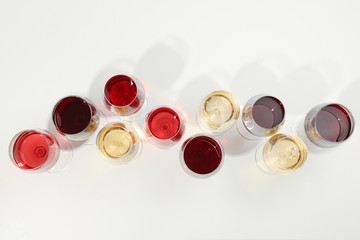 Flat lay composition. Glasses with different wine on white background, top view