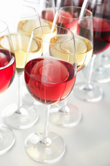 Glasses with different wine on white background, close up