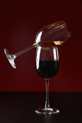 Glasses with wine against red background, copy space