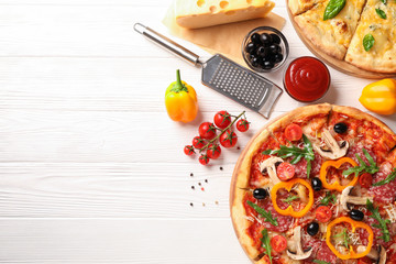 Delicious pizza and ingredients on white wooden background, copy space