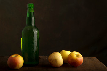 till life with bottle of green cider and apples