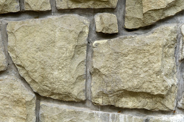 The vertical wall is faced with a rough, rough chopped stone. Natural background for designers.