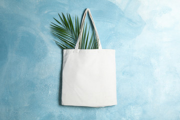 Tote cotton bag with palm leaf on color wall, space for text