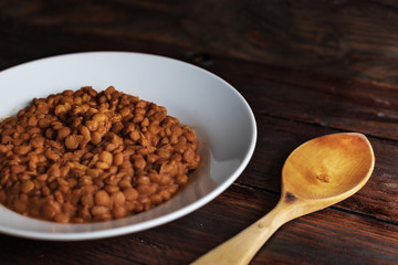 plate of lentils with wooden spoon