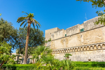 Fototapeta na wymiar Italy, Bari, view of the public gardens in front of the Svevo castle, an imposing fortress dating back to the 13th century.