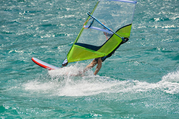Water sports on Lake Garda in Torbole resort. Windsurfer Surfing The Wind On Waves, Recreational...