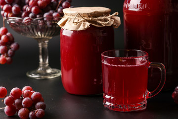 Grape juice in a glass and a cans, cooked in a juicer, harvesting juice from a grape harvest...
