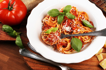 Plate of delicious spaghetti Bolognaise or Bolognese with savory minced beef and tomato sauce garnished with parmesan