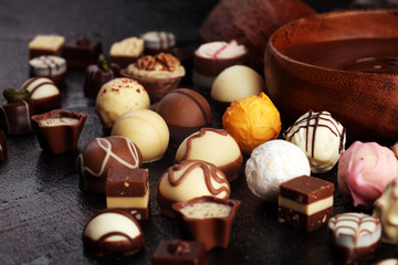 a lot of variety chocolate pralines, belgian confectionery gourmet chocolate on rustic dark...