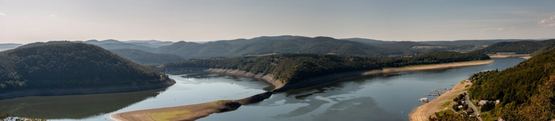 Obraz premium Wide panorama with low water after drought at the Edersee in Germany seen from the Waldeck castle