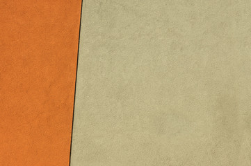 Ausschnitt Fassade zweifarbiger Putz in Beige und orange mit schräger schwarzer Trennlinie