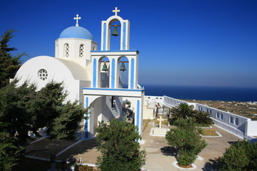 Piękny niebiesko-biały kościół na wzgórzu, widoczny na tle błękitnego nieba, wyspa Santorini, Grecja - obrazy, fototapety, plakaty