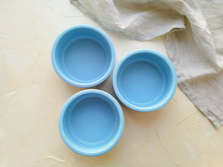 Three blue baking molds on a light background top view. Utensils for cooking.