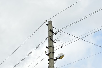 Obraz premium Lamppost with a lantern and electric wires.
