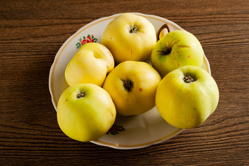 green apples in a white plate on a table