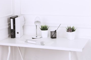 White and stylish home interior with cool office accessories, notes, boxes, pencils and air plant.
