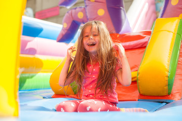 A cheerful child plays in an inflatable castle
