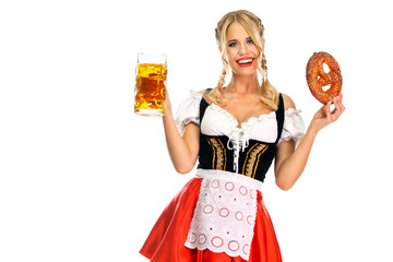 Smiling young sexy Oktoberfest girl waitress, wearing a traditional Bavarian or german dirndl, serving big beer mugs with drink and bretzel, isolated on white background.