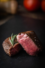 rare grilled tenderloin beef steak on cutting board with vegetables