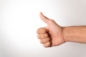 Hand making thumbs up sign isolated over white
