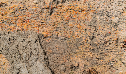 The texture of the brick. Rough surface with gray and orange colors. Surface with different jaggies