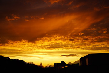burning sky over the city, clouds like fire at sundown