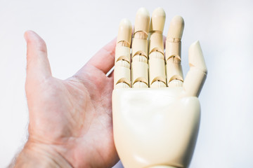 real hand holding prosthetic hand isolated on white
