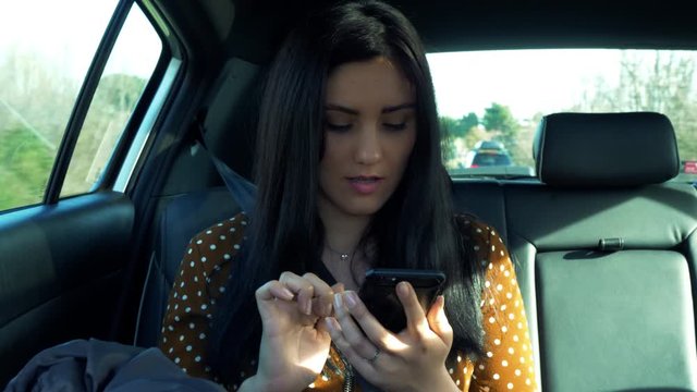 Woman in car writing text with cell phone chatting