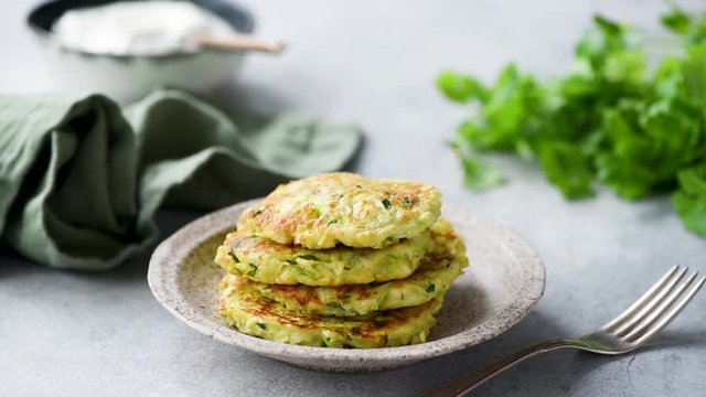 Stop motion animation with food. Vegetarian vegetable zucchini fritters on plate. Fun with food