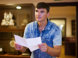 Man with brochure looking at exposition
