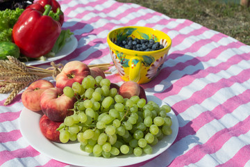 Grape and peach on a plate. Fruits close up. Beautiful picnic.