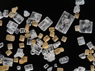 Brown and white sugar crystals macro photography isolated onthe black background