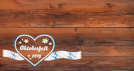 Lebkuchenherz mit Text "Oktoberfest 2019" auf alter Holzstruktur