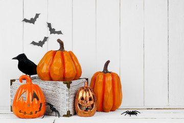 Halloween display with jack o lantern decor and pumpkins against a rustic white wood background....