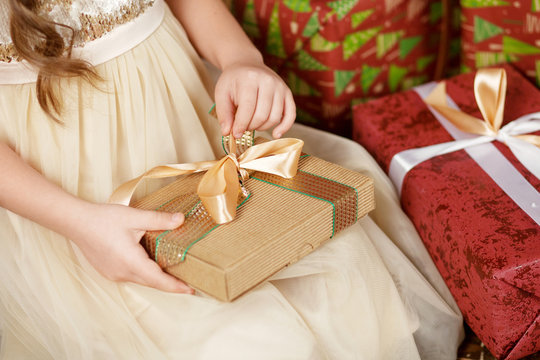 Beautiful little girl opening a Christmas gift box. Christmas and New Year celebration concept. Winter holidays. Close up picture