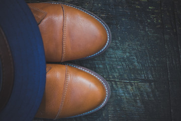 Brown leather boots on the wooden background