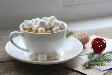Cappuccino with marshmallows in cup on brown wooden table