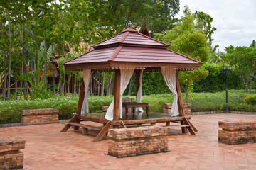 Naklejka premium Kanchanaburi, Thailand, 09.09.2019: Beautiful garden, lake, traditional Thai, Siamese clothes, buildings of 