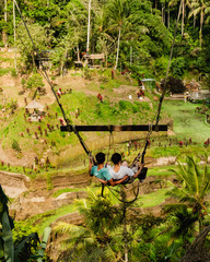 Fresh married couple on one of the famous balinese swing. Tegalalang Rice Terrace, Bali, Indonesia.